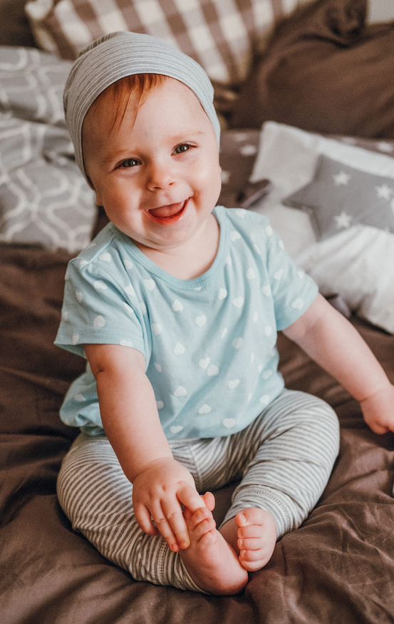 Bebe sonriendo sentado en la cama