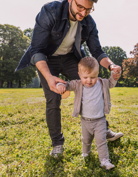 dad helping baby to walk 